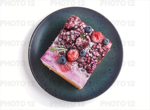 Berry cake with milk cream and blueberry jam on blue ceramic plate isolated on white background. top view, close up, flat lay