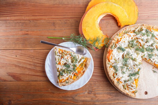 Sweet pumpkin pie with cheese and dill on brown wooden background. top view. copy space