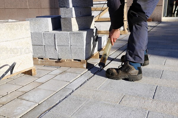 Worker lays paving stones