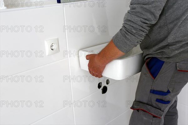 Plumber installs a new washbasin