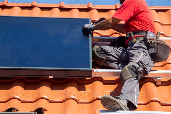 Installation of solar collectors for solar thermal energy. The company Hanschke Solarmontagen installs solar panels on a newly built apartment block in Mutterstadt (Palatinate)