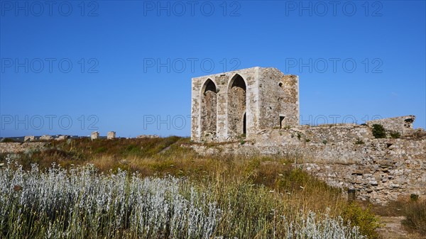 Large ruins in the middle of a wild floral landscape under a deep blue sky, Methoni sea fortress, Peloponnese, Greece, Europe