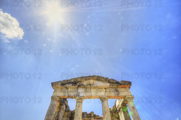 Sunshine pierces the ruins of an ancient temple with columns against a blue sky, Mausoleum, Heroon, Archaeological Site, Ancient Messene, Capital of Messinia, Messini, Peloponnese, Greece, Europe