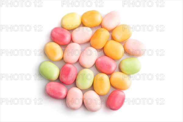 Heap of multicolored caramel candies isolated on white background. close up, top view, flat lay