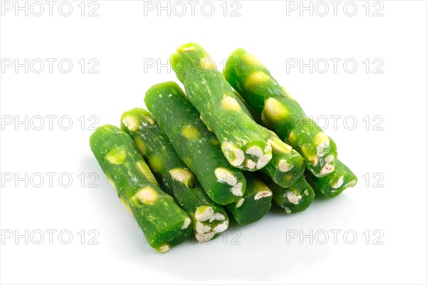 Green traditional turkish delight (rahat lokum) with peanuts isolated on white background. side view, close up
