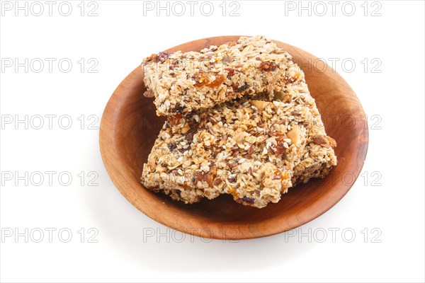 Homemade granola from oat flakes, dates, dried apricots, raisins, nuts in brown wooden plate isolated on white background. side view, close up, macro