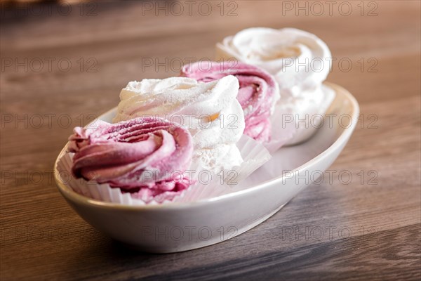 Pink and white homemade marshmallows (zephyr) on a gray wooden background