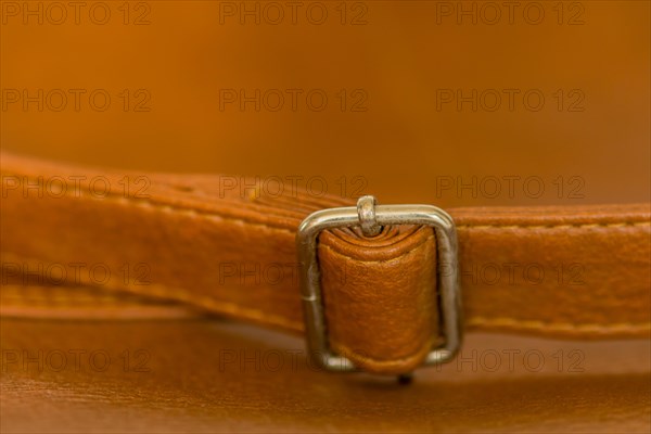 Metal adjustment clip on strap of leather shoulder bag
