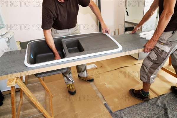 Craftsmen installing a new kitchen (kitchen assembly)