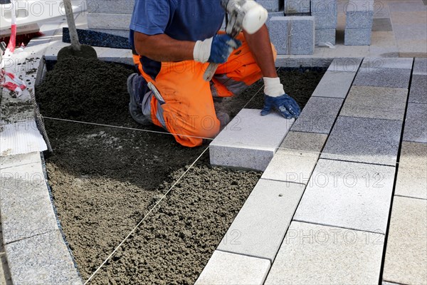 Worker lays paving stones