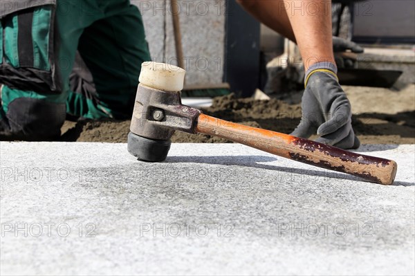 Worker lays paving stones