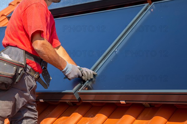 Installation of solar collectors for solar thermal energy. The company Hanschke Solarmontagen installs solar panels on a newly built apartment block in Mutterstadt (Palatinate)