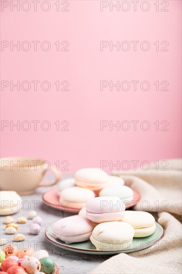 Colored zephyr or marshmallow with cup of coffee and dragees on a gray and pink background and linen textile. Side view, close up, selective focus, copy space