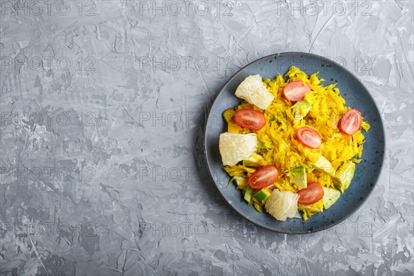 Fried pomelo with tomatoes and avocado on gray concrete background. Top view, copy space, myanmar food