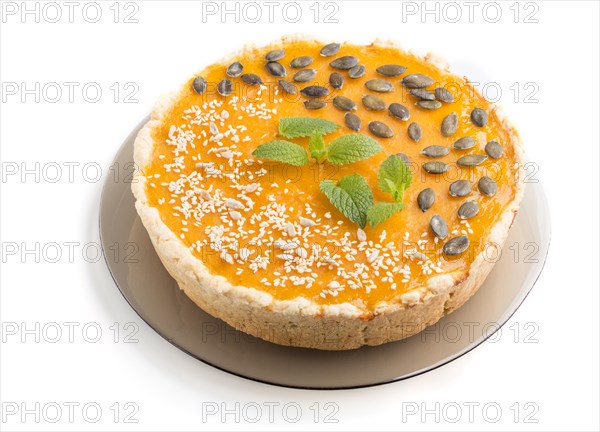 Traditional american sweet pumpkin pie decorated with mint, sesame and pumpkin seeds isolated onwhite background. side view, close up