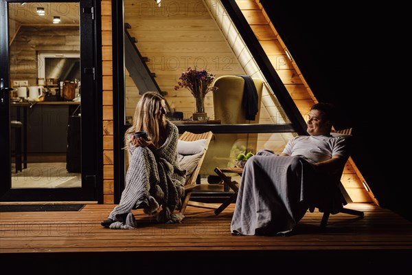 An evening conversation between a friendly couple on the terrace of tiny house