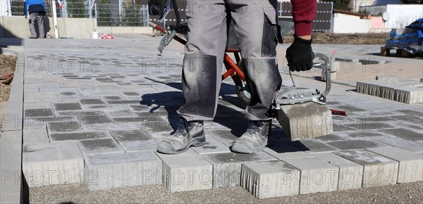 Workers lay paving stones