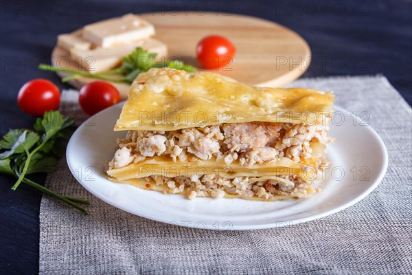 Lasagna with minced meat and cheese on black wooden background. close up