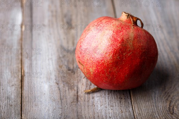 Ripe garnet on a rustic wooden background