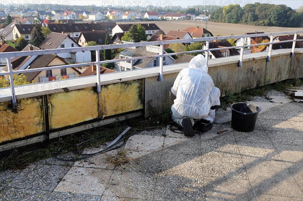 Professional asbestos removal by workers in protective suits