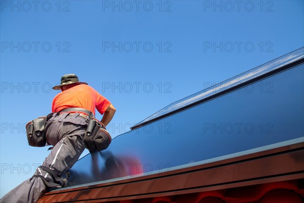 Installation of solar collectors for solar thermal energy. The company Hanschke Solarmontagen installs solar panels on a newly built apartment block in Mutterstadt (Palatinate)