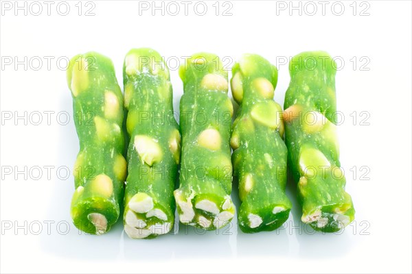 Green traditional turkish delight (rahat lokum) with peanuts isolated on white background. side view, close up