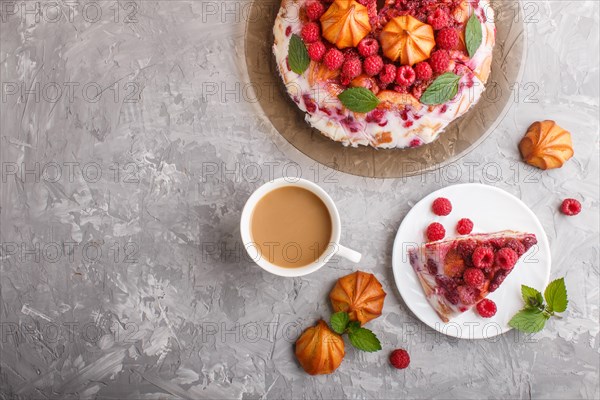 Homemade jelly cake with milk, cookies and raspberry on a gray concrete background with cup of coffee. top view. flat lay, copy space