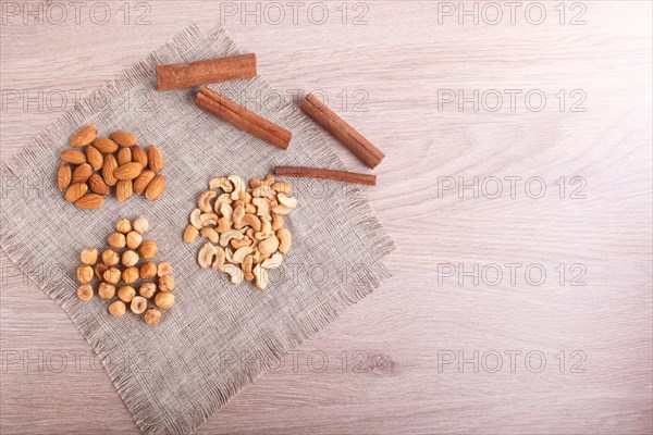 Cinnamon, almonds, hazelnuts, cashew on a linen napkin. Still life. Closeup. copy space