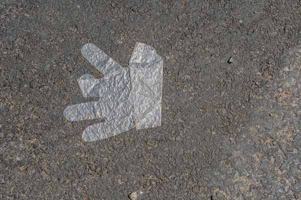 Plastic disposable glove discarded on street pavement in South Korea