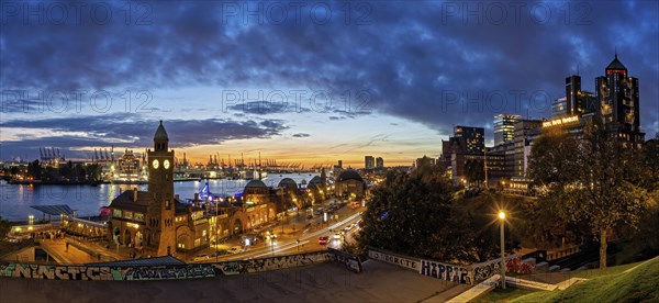 A panoramic picture above the Landungsbruecken in Hamburg with the Hamburg harbour in the background in the evening light with the striking tower