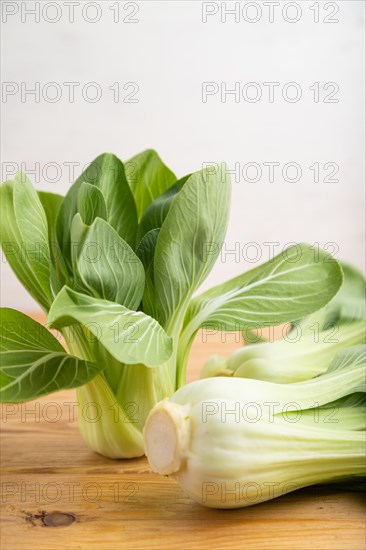 Fresh green bok choy or pac choi chinese cabbage on a brown wooden background. Side view, close up, selective focus