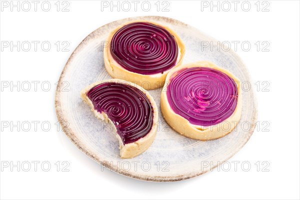Sweet tartlets with jelly and milk cream isolated on white background. Side view, close up