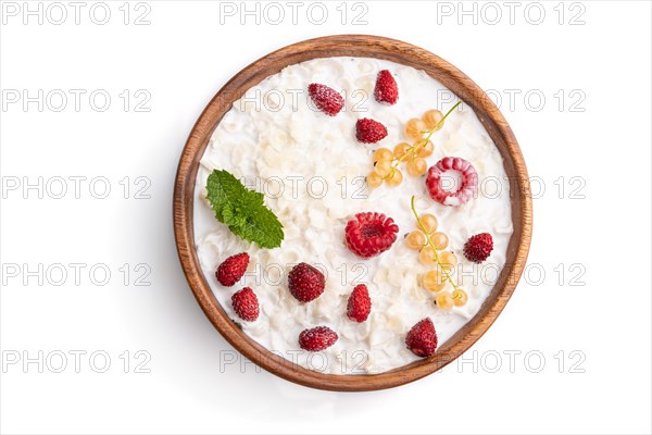 Rice flakes porridge with milk and strawberry in wooden bowl isolated on white background. Top view, flat lay, close up