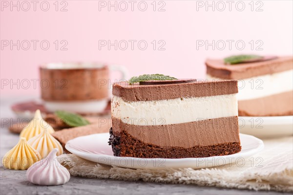 Cake with souffle milk chocolate cream with cup of coffee on a gray and pink background and linen napkin. side view, close up, selective focus