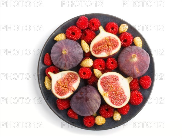Fresh figs, strawberries and raspberries on blue ceramic plate isolated on white background. top view, flat lay, close up