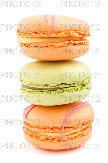 Orange and green macarons or macaroons cakes isolated on white background. side view, close up, macro