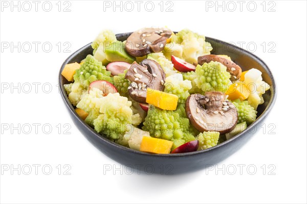 Vegetarian salad from romanesco cabbage, champignons, cranberry, avocado and pumpkin in black bowl isolated on a white background. side view, close up