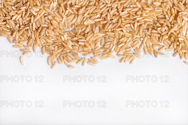 Texture of brown rice isolated on white background. Top view. Copy space