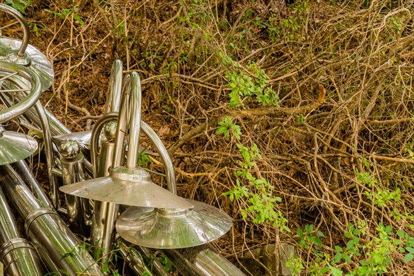 Discarded chrome plated lampposts laying on in dried vegetation on ground in South Korea
