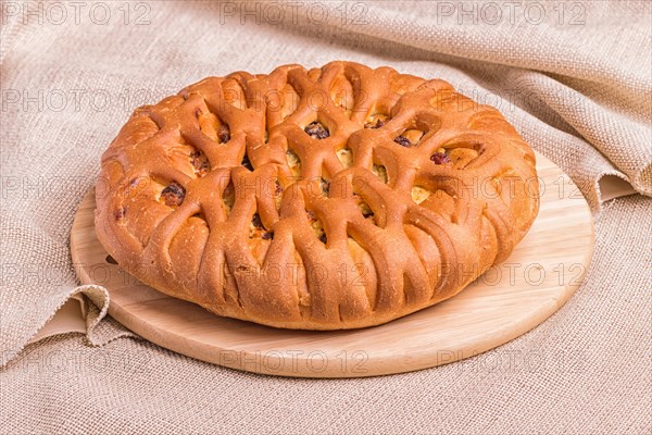 Sweet buns on a wooden board and linen tablecloth