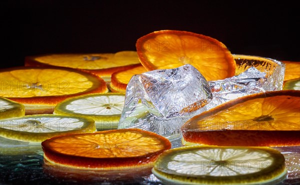Transparent slices of fresh oranges and lemons on the glass with ice