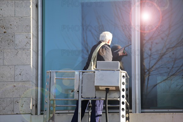 Workers cleaning glass in an office building