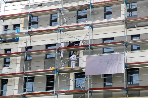 Painter painting the facade of a new apartment building