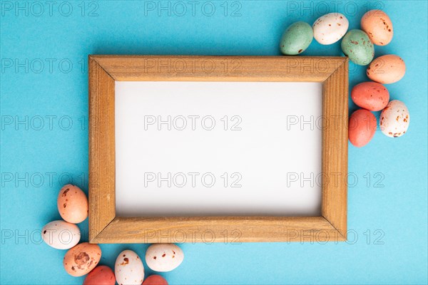 Composition with candies and wooden frame on blue pastel background. copy space, top view, flat lay, template