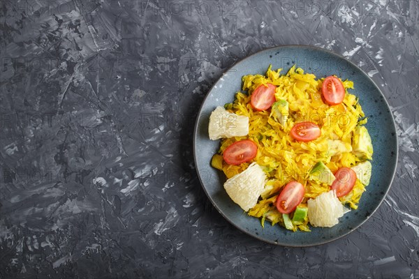 Fried pomelo with tomatoes and avocado on black concrete background. Top view, copy space, myanmar food