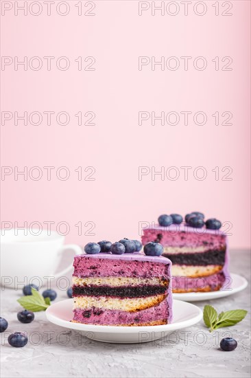 Homemade cake with souffle cream and blueberry jam with cup of coffee and fresh blueberries on gray and pink background. side view, selective focus, copy space