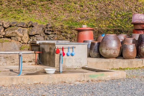 Public use water faucets with plastic dippers and bowl for use by hikers and travelers visiting the area in South Korea
