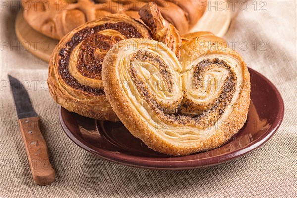 Sweet buns on a wooden board and linen tablecloth