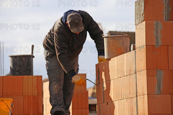 Bauarbeiter (Maurer) auf der Baustelle (Bauarbeiter (Maurer) arbeitet auf der Baustelle)