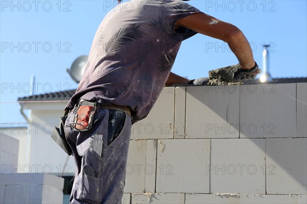 Construction worker (bricklayer) on the building site